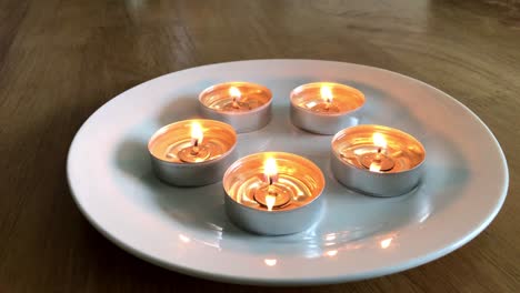 candles on a plate with dancing flames