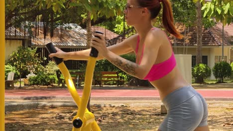 woman exercising outdoors on a gym machine