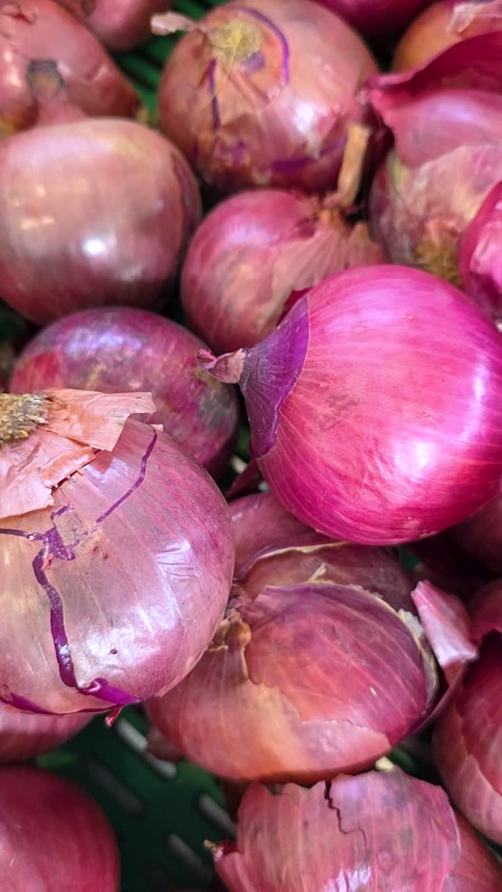 Cipolle rosse fresche su una bancarella del mercato, colori vivaci, trama naturale.