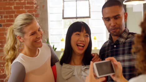 group of executives reviewing picture on mobile phone 4k