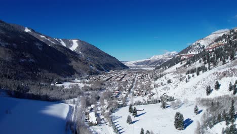 Rising-drone-aerial-view-of-Telluride,-Colorado-on-a-sunny-winter-day