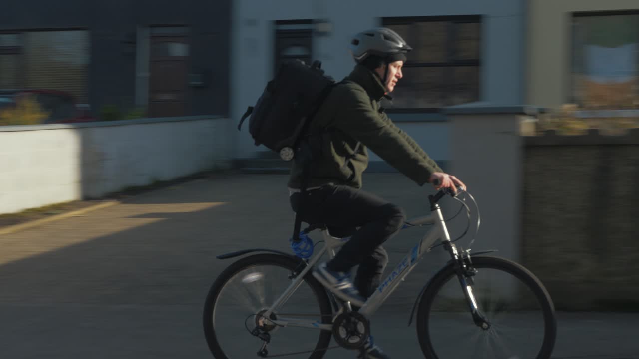 아일랜드 타운의 도로를 따라 여행하는 자전거 타는 사람을 따라가다