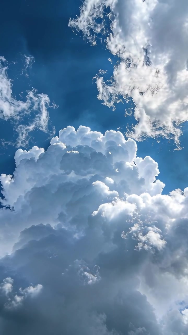 Video verticale: Luce solare che si sposta, mostrando una nuvola cumuliforme che forma creste contro un cielo blu con scie.