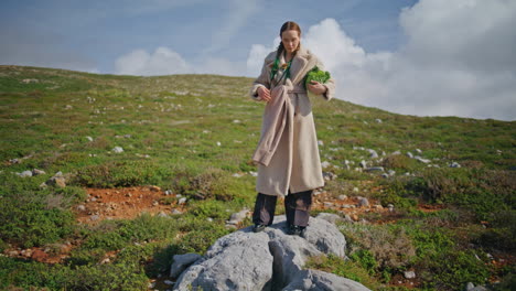 woman standing green hillside with fresh vegetables. farm girl holding cabbage