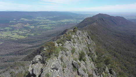 aerial retreats from steep, craggy sugarloaf peak in victoria, aus