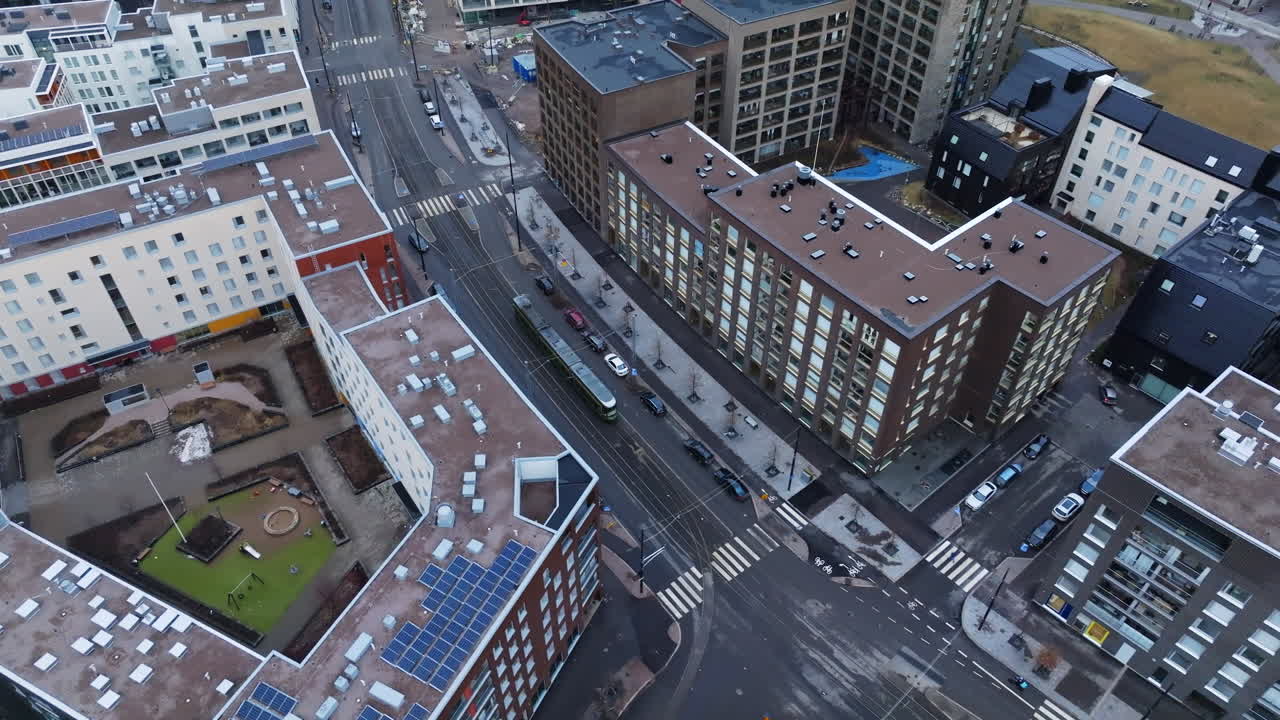 Aerial view following a lightrail on the streets of Helsinki, cloudy spring day