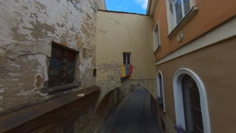 bandera lituana sobre el arco en la estrecha calle de la ciudad vieja en vilnius, lituania