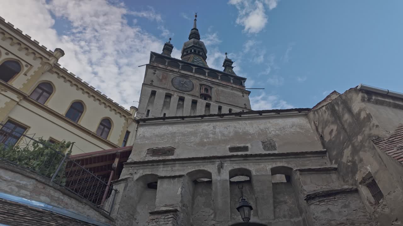Sighisoara clock tower landmark above medieval citadel arch gateway, Pan Up