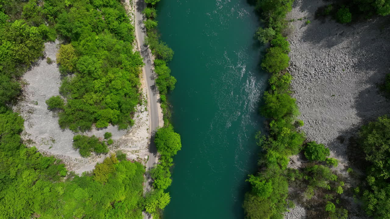 Veduta aerea di un fiume verde che si snoda attraverso una fitta foresta, mettendo in risalto i colori vivaci della prima primavera
