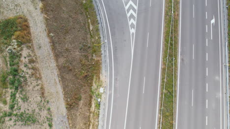 Vista-Aérea-De-Cerca-Volando-Por-Encima-De-Los-Carriles-De-Autopista-De-Transporte-Vacíos-En-Un-Campo-Tranquilo