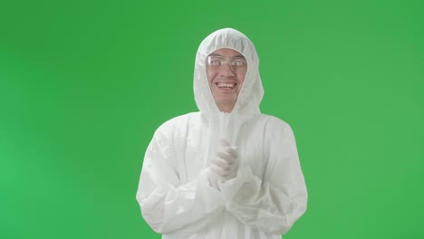 asian man wearing personal protective equipment uniform ppe and clapping his hands in the green screen studio