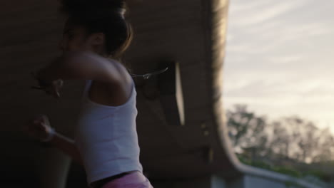 mujer bailarina joven bailarina hispana de hip hop en la ciudad disfrutando de frescos movimientos de baile urbano freestyle practicando giros al atardecer