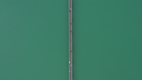 fix vertical aerial shot over a lake view of a road with cars crossing france