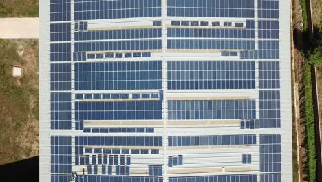 Roof-Of-A-Building-In-A-Cement-Factory-Almost-Filled-With-Solar-Panels---Aerial-Shot