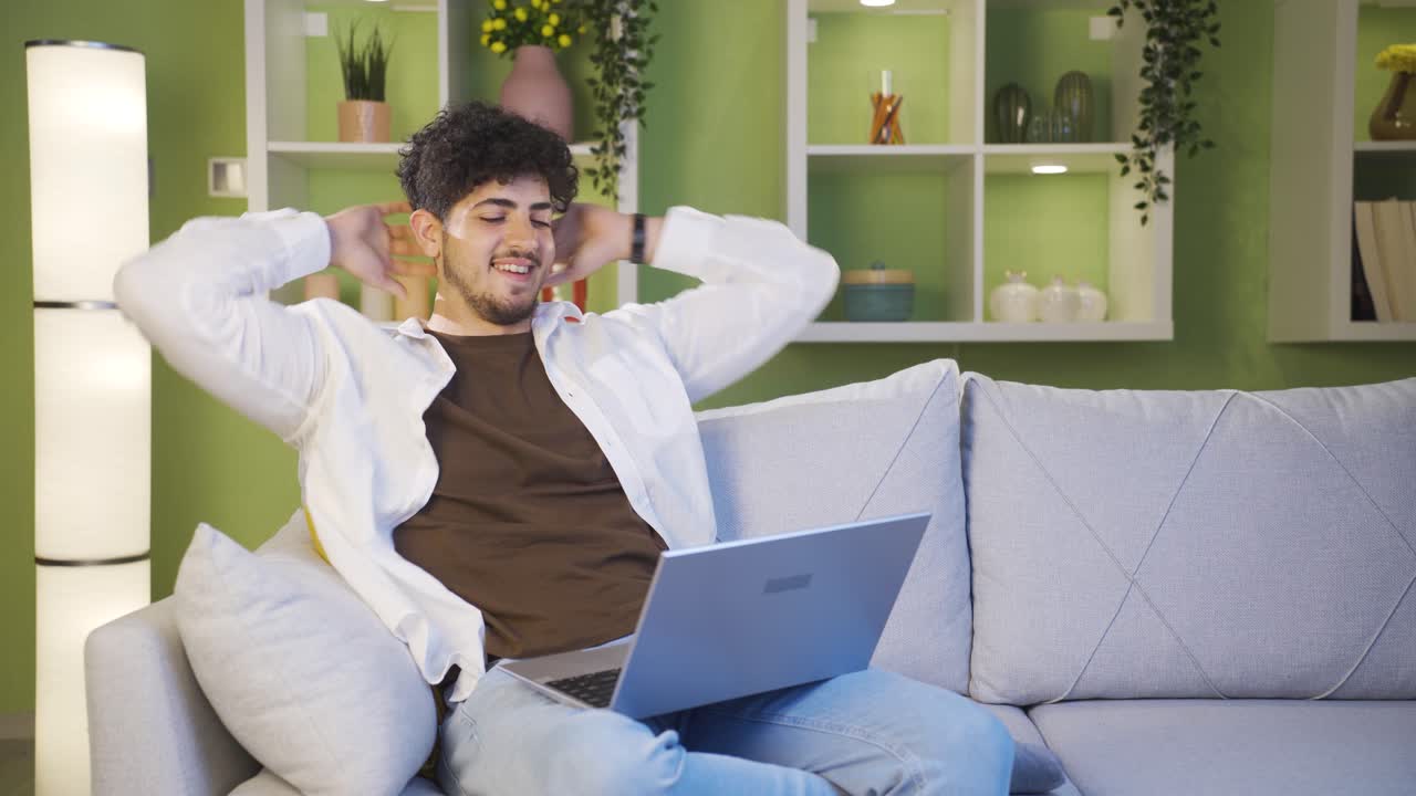 Happy young man completing his work, relaxing.