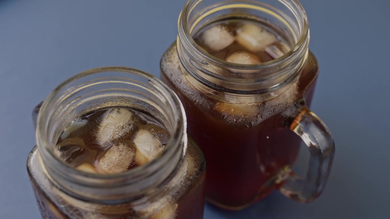 Bicchieri di caffè freddo con cubetti di ghiaccio visibili, video in primo piano.