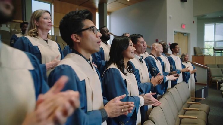 Clapping choir members on conductor cue singing during worship at church, blue robes beige stoles