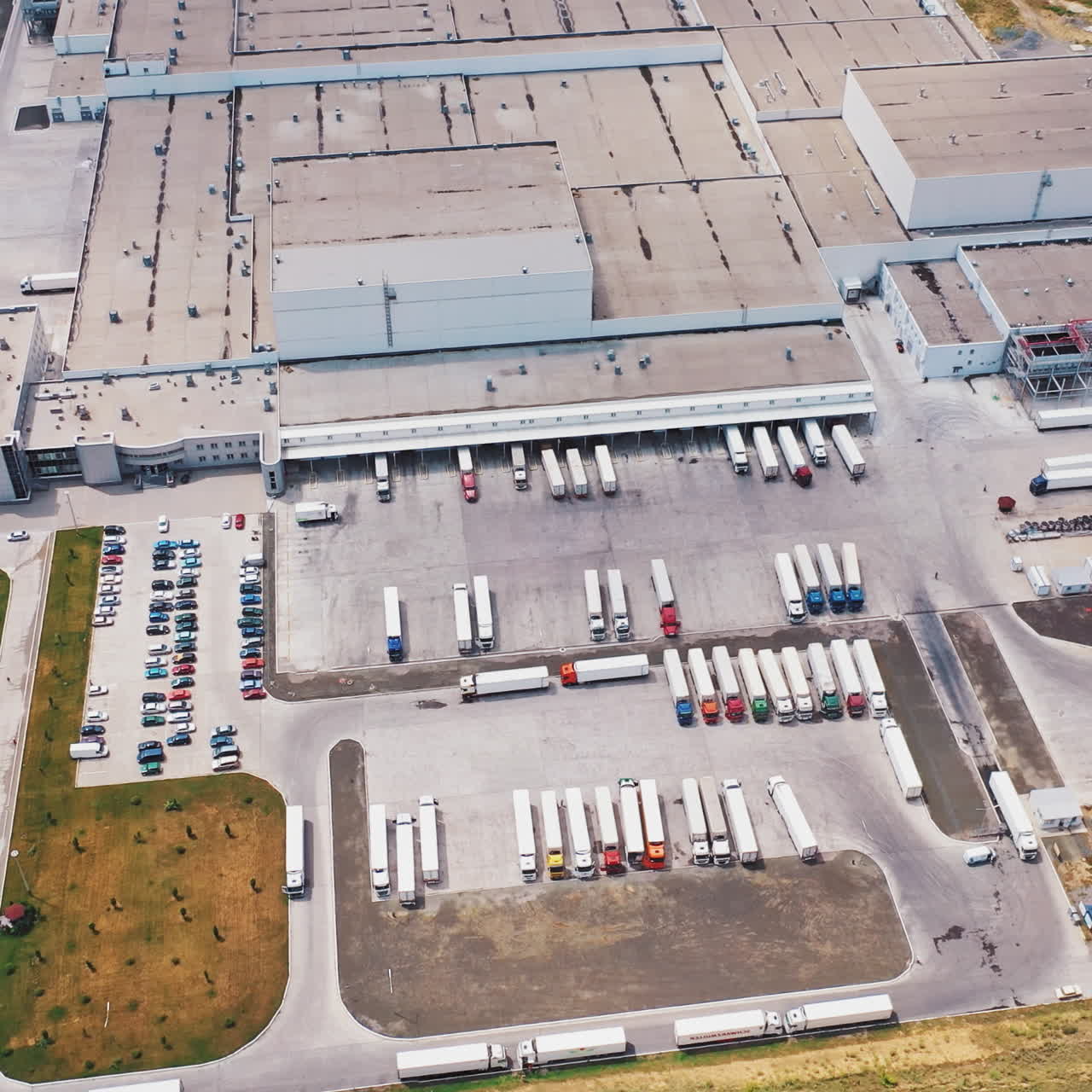 Luftfoto af lagerbygning med lastbiler. Industriel baggrund. Logistik ovenfra