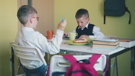 los estudiantes de escuela primaria descansan en la mesa con comida rápida en la habitación