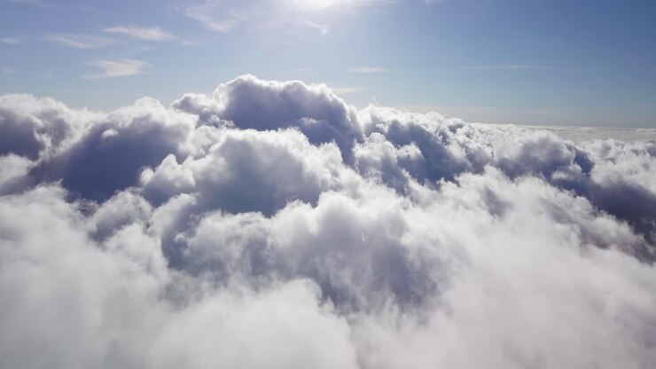 Aerial view over high cumulonimbus clouds on a sunny day under a blue heaven