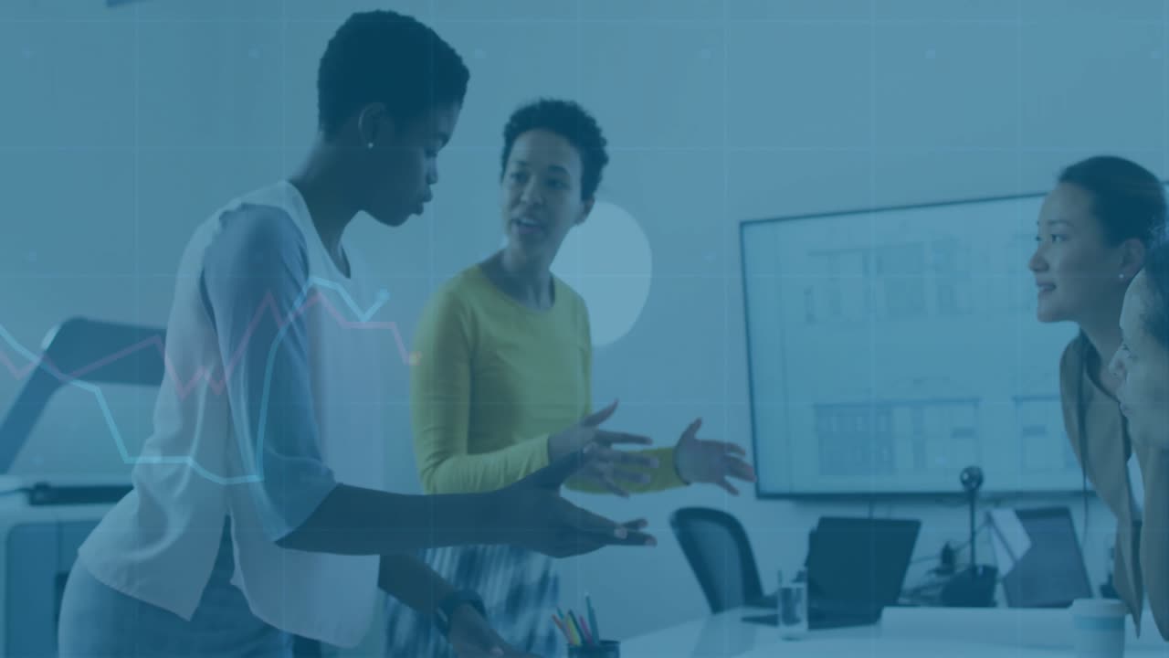 Two women working at desk, reviewing documents and discussing business planning with data graphics