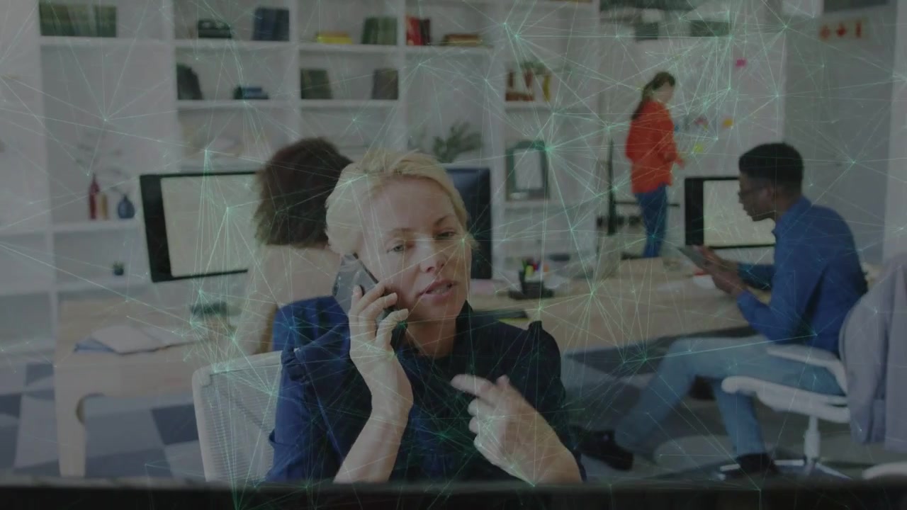 Seated woman taking mobile call and handling office tasks, speaking, gesturing, network overlaying