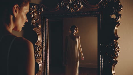 woman looking at her reflection in an ornate mirror