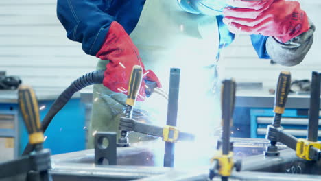 asia technician worker working wearing industrial uniforms and welded iron mask at steel welding plants with sparks flying, industrial safety first concept.