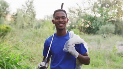 African-American-man-smiling-and-looking-at-camera-during-river-clean-up-day