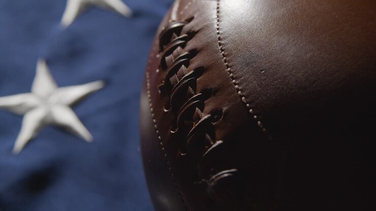 La cámara se acerca para un primer plano de estudio de un balón de fútbol americano sobre la bandera de barras y estrellas