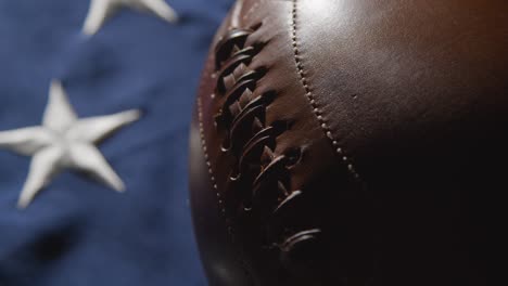 camera pushes in for close up studio shot of american football on stars and stripes flag