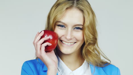 Attractive-Blue-Eyed-Woman-With-Red-Apple-Filmed-At-Studio-On-A-White-Background
