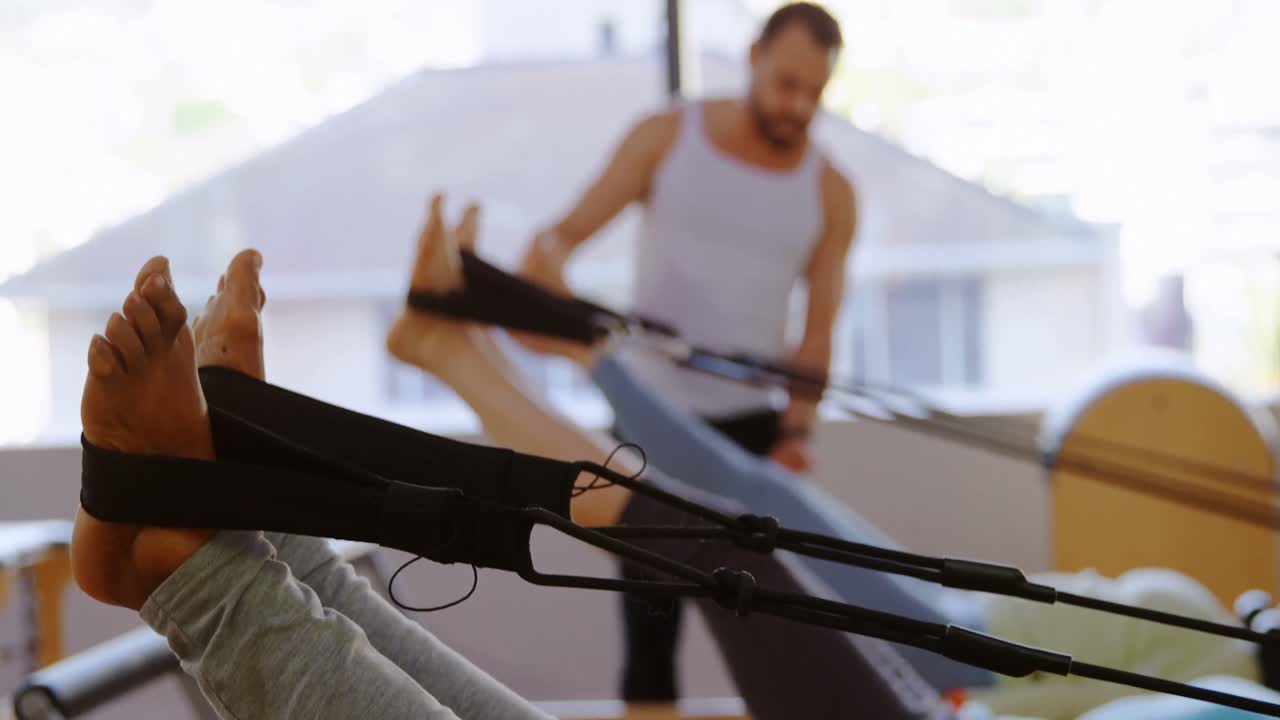 Trainer assisting senior women while stretching exercise 4k