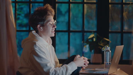 cheerful woman chatting on video call in the evening at home
