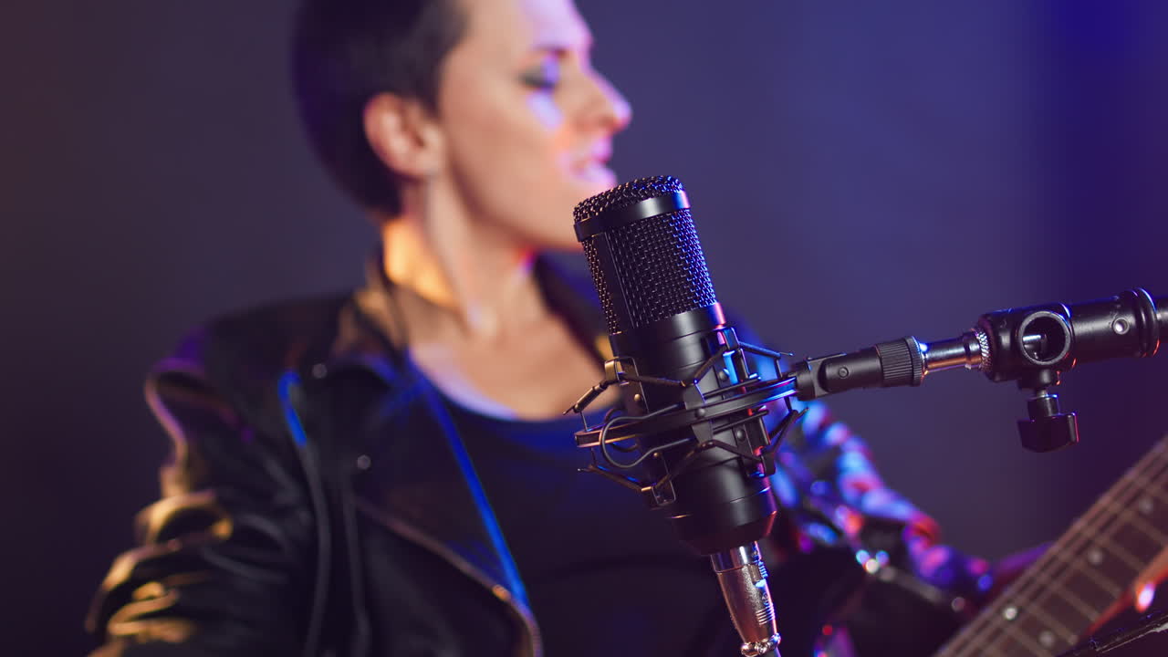 Woman Performing Music with Microphone and Guitar