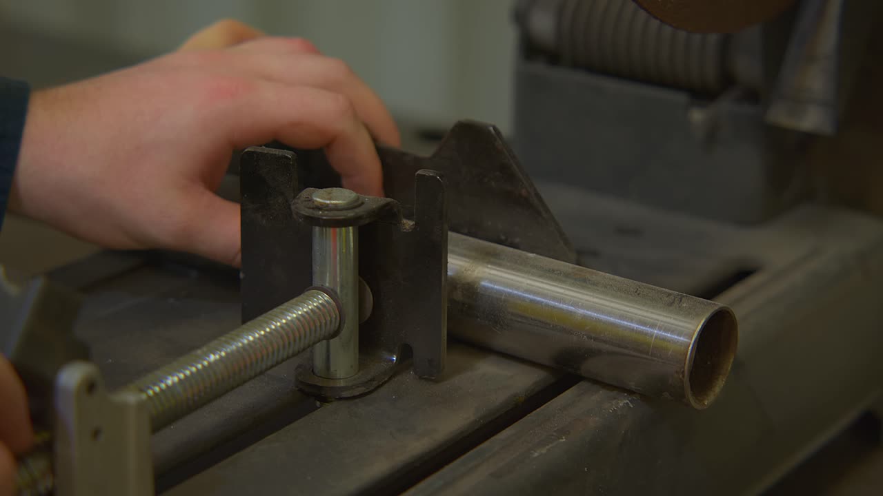 primer plano de la mano del trabajador apretando el palo de hierro para cortar