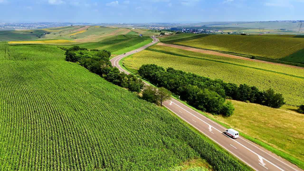 Patchwork fields and lake in Romania. Aerial photo of colorful farmland and reflective lake under a blue sky