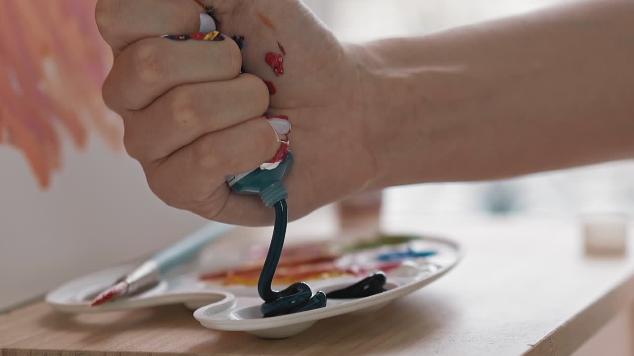 el estudiante de arte exprime pintura azul oscuro en una taza en la paleta