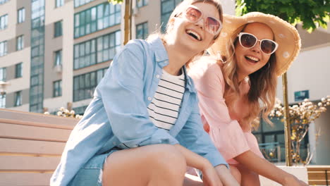 two happy women sitting on a bench