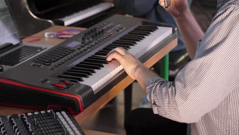 musician playing keyboard in a studio