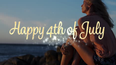 happy 4th of july greeting and woman sitting by the beach