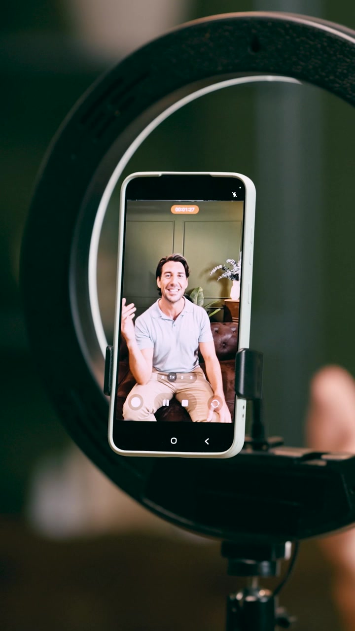 Uomo che registra contenuti video sullo smartphone con ring light