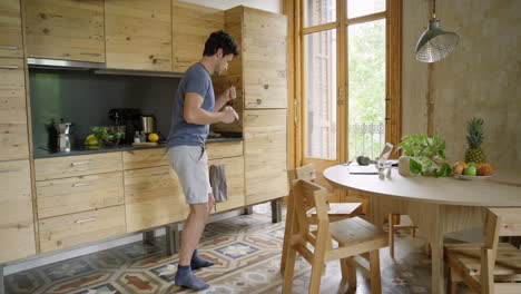 hombre divertido bailando en el bucle de la cocina divirtiéndose bailando sintiéndose feliz en casa