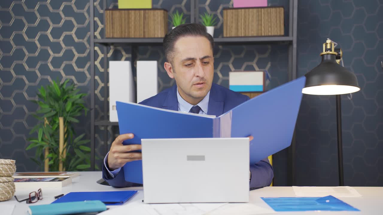 un hombre de negocios enfurecido cierra los archivos de papeleo.