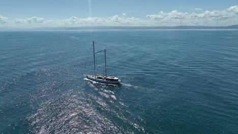 Sailboat-sailing-off-coast-of-Samana-on-sunny-day,-Dominican-Republic