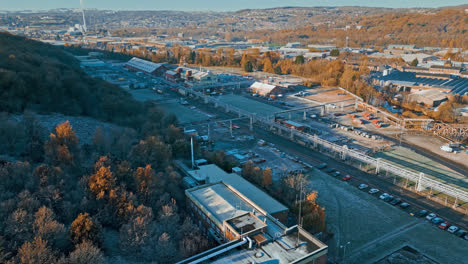 aerial footage moving towards a large industrial chemical plant, showing pipelines, metal structures, cooling towers and chemical storage
