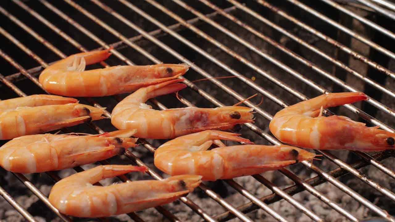 Chef cooking shrimps with oil and spices on grill close-up. Prawns on fire throwing them on pan. Restaurant Food concept. Sea food barbecue.