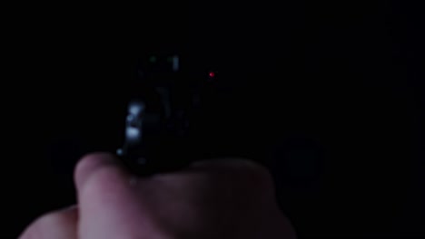 pov of pistol firing a single shot in a dark room