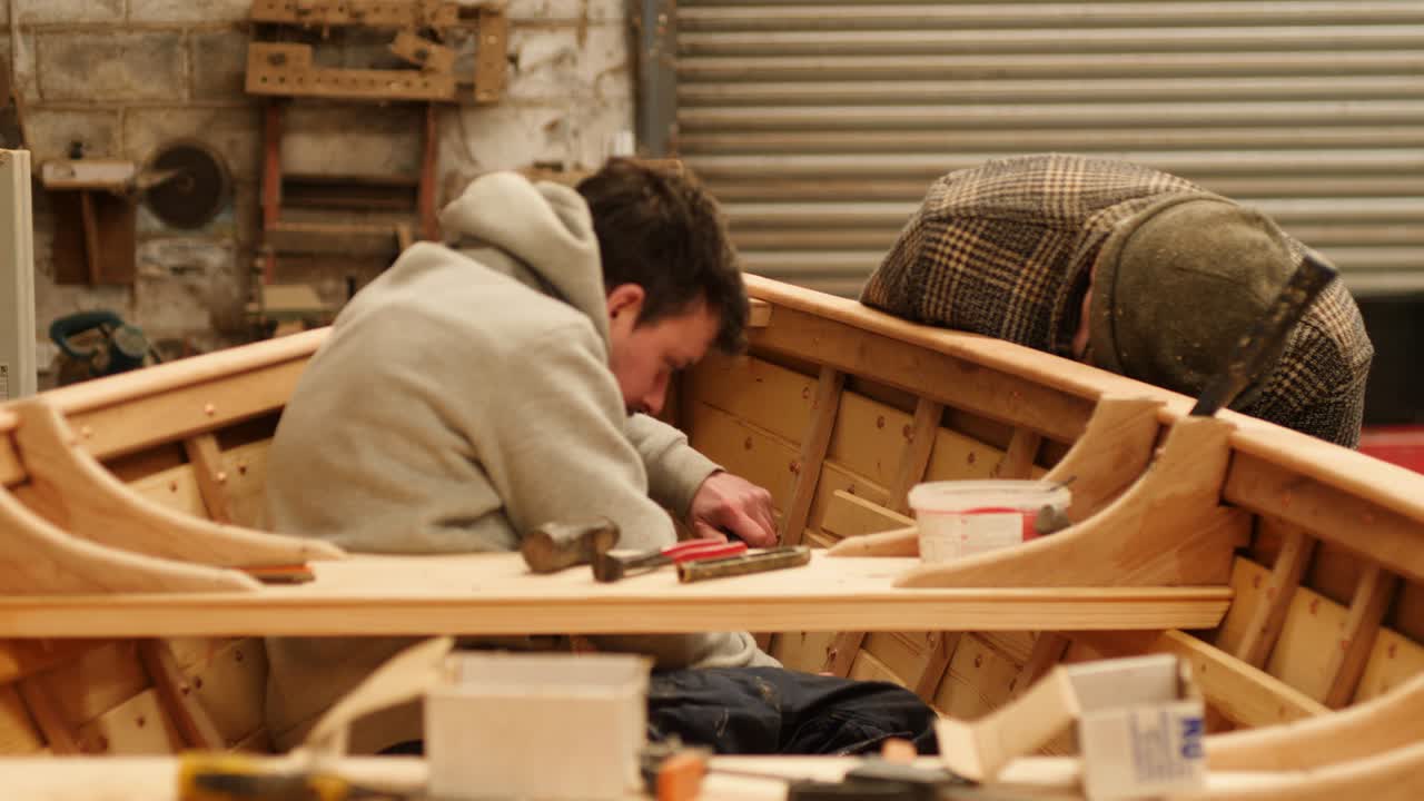 Skilled Craftsmen Working on Copper Riveting wooden boat