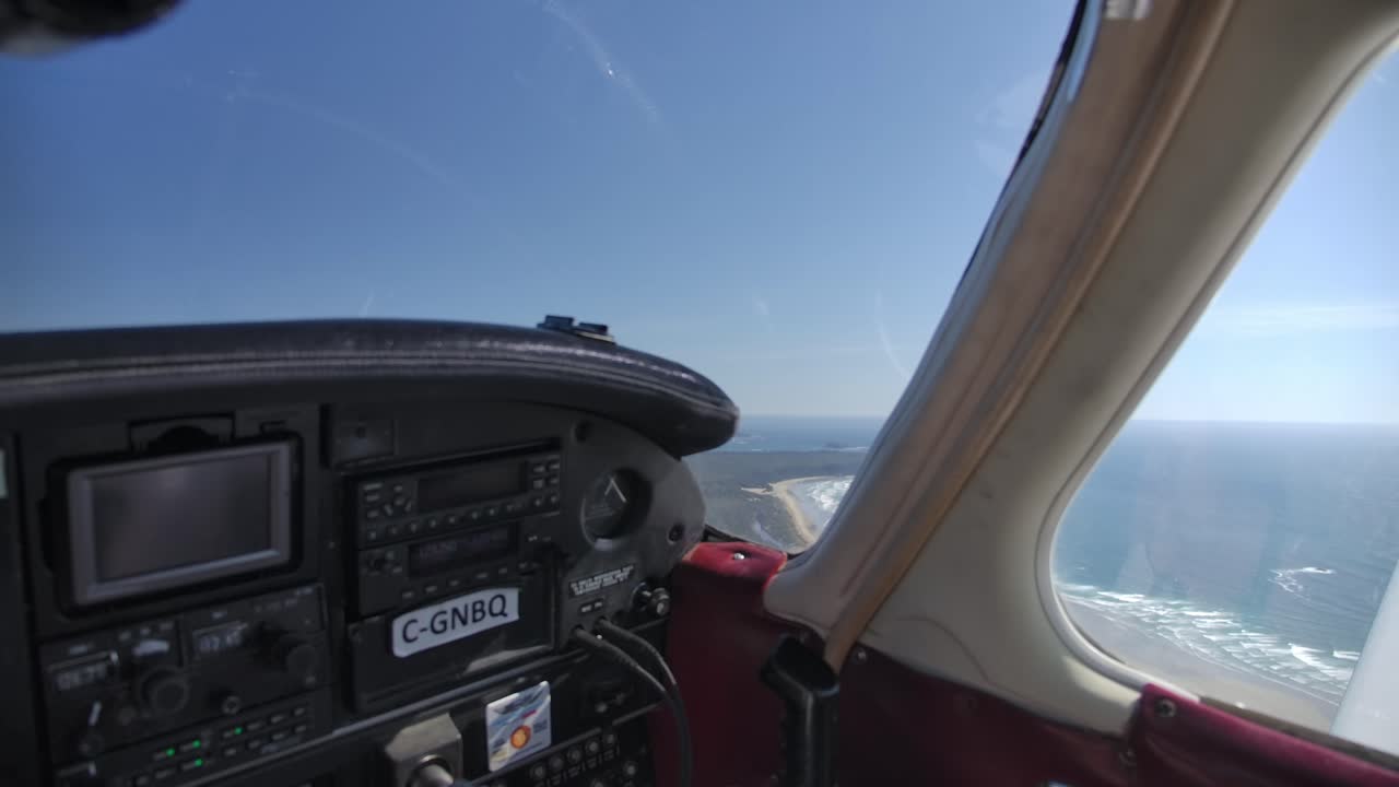 avión sobrevolando una hermosa playa en un día soleado, vista desde la cabina